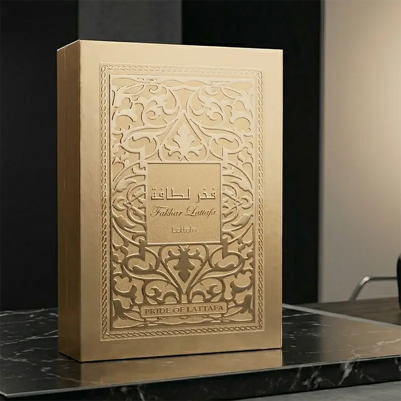 Original gold box packaging for Lattafa Fakhar Perfume Extrait Gold showcasing its textured surface design.