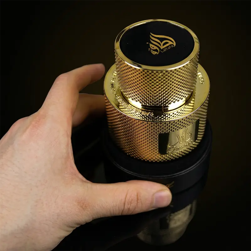 Top-down view of the gold-textured Lattafa Qaa'ed bottle showing the embossed brand logo on the cap.